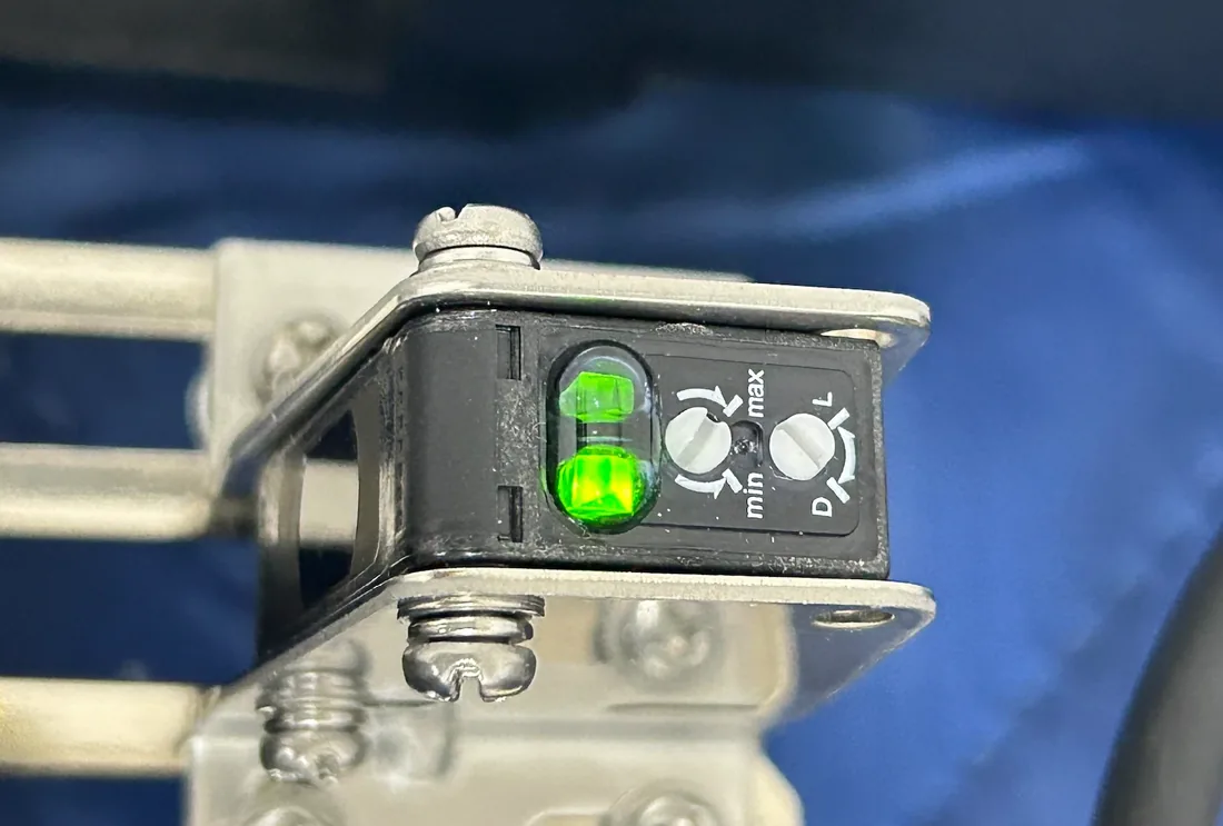 Step 02 — choosing components and testing on the real product (a photoelectric sensor being adjusted)