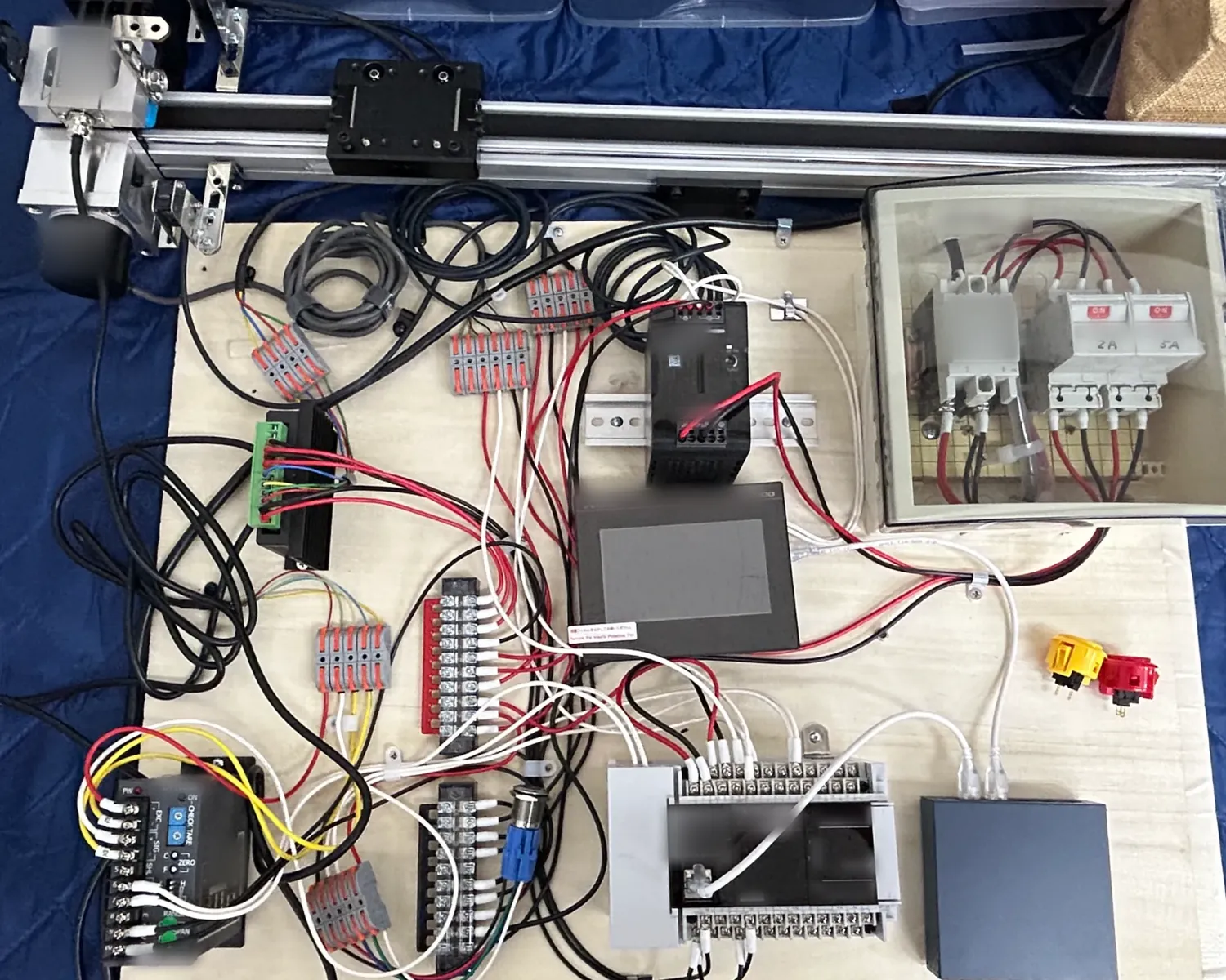 The tension-and-extension instrument as built: load cell, linear rail, encoder, PLC, touch panel and measurement amplifier